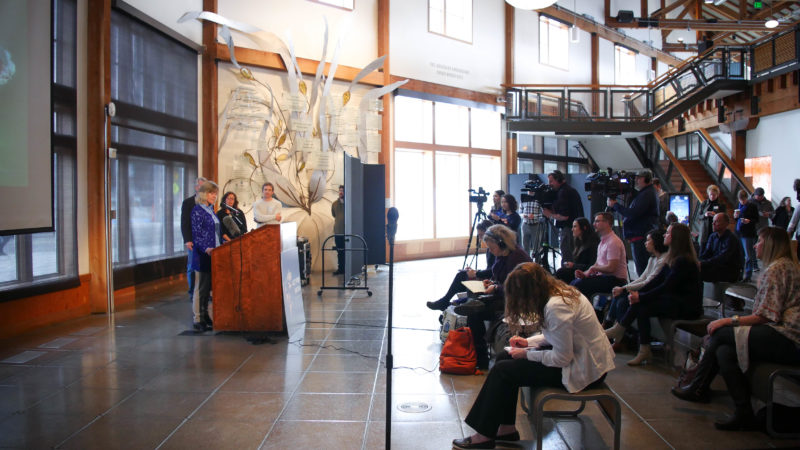 orca recovery task force press conference at seattle acquarium. mindy roberts, puget sound program director, speaks at the podium in front of a crowd of reporters.