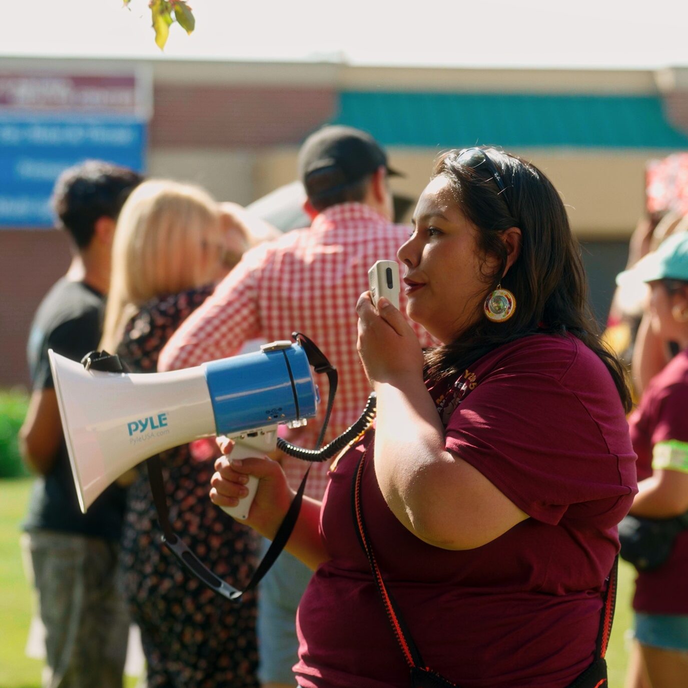 Maricela Santana, ELLA Environmental Justice Coordinator in Lower Yakima Valley, speaks into a megaphone at an event.